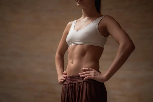 Close up of smiling lady wearing sports clothes and putting hands on the hips — Stock Photo, Image