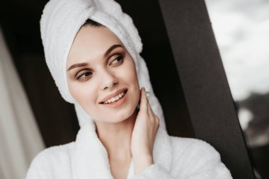 Teras üzerinde bornoz duran genç kadın