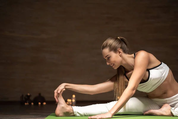 Ayağı için eğilerek ve asanas yaparken gülümseyen mutlu Bayan — Stok fotoğraf