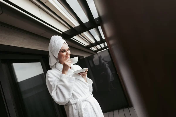 Молодая женщина в халате с чашкой чая — стоковое фото