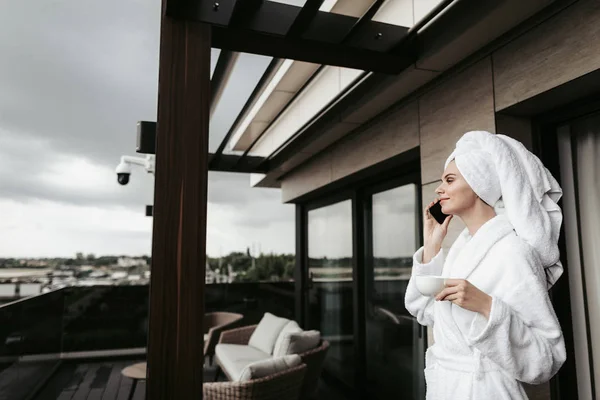 Jonge vrouw in badjas praten via de telefoon — Stockfoto