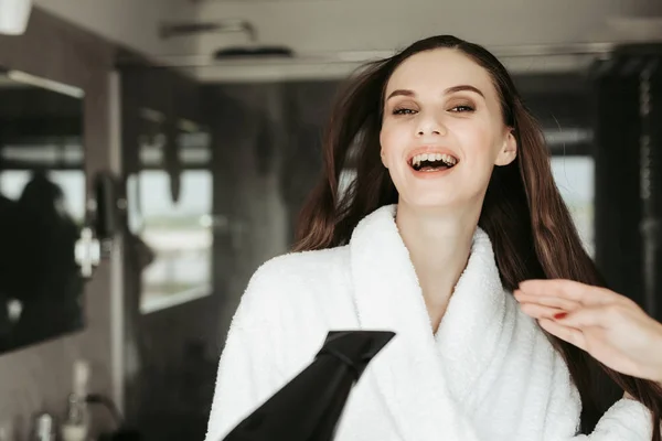 Veselá dívka sušení s blowdryer vlasy — Stock fotografie
