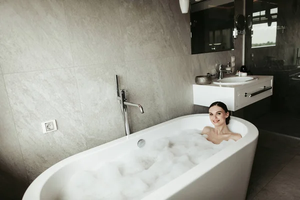 Jovem senhora sorrindo tomar banho de espuma relaxante — Fotografia de Stock