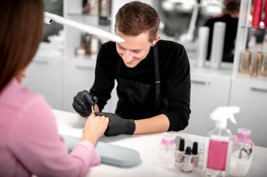 Mutlu genç gülümseyen ve boyama çivi, müvekkilinin adam