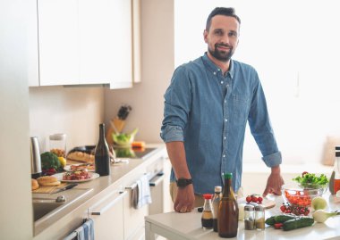 Sakallı yakışıklı beyaz tonlarda rahat mutfak at poz