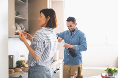 Adam açılış şişe şarap gözlük tutan Bayan süre gülümseyen