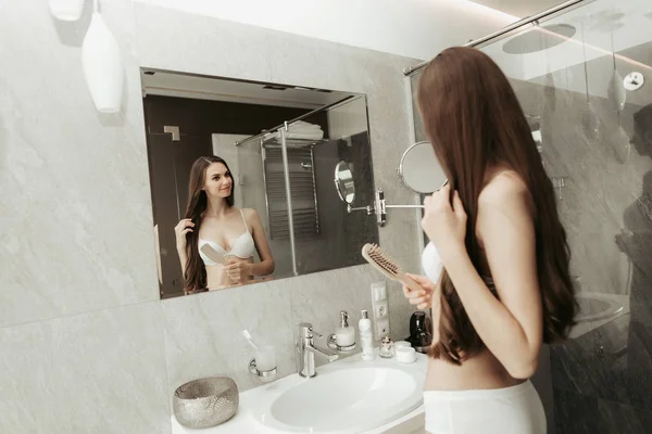 Femme positive gardant brosse à cheveux dans le bras intérieur — Photo