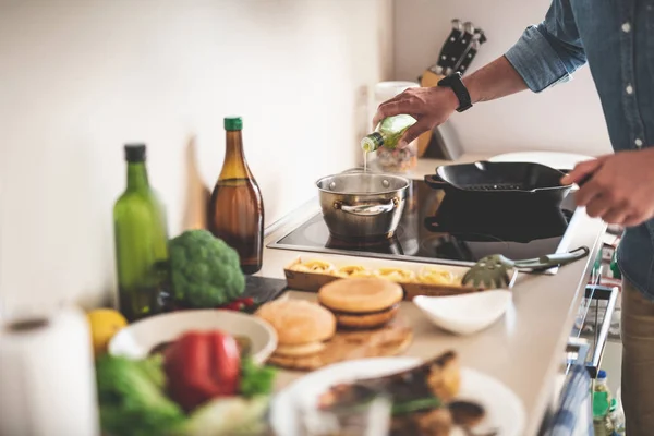 Man gieten van olijfolie in de pot op fornuis — Stockfoto