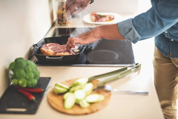Man koken van heerlijke biefstuk in keuken — Stockfoto