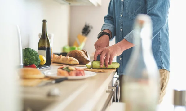 Man hands cutting fresh zucchini on wooden cutting board — Stock Photo, Image