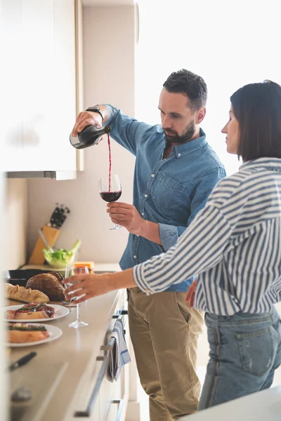 Skäggiga gentleman hälla vin i glas medan hans flickvän väntar — Stockfoto