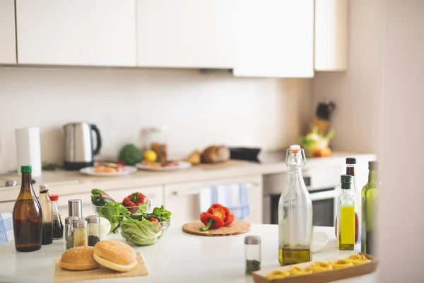 Interior de la cocina en tonos blancos con comida en la mesa —  Fotos de Stock