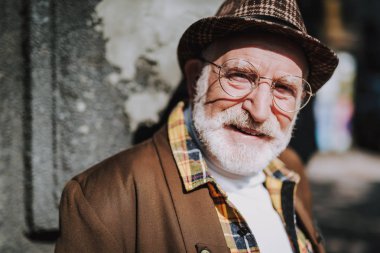 Neşeli şık yaşlı adam sokakta yürürken