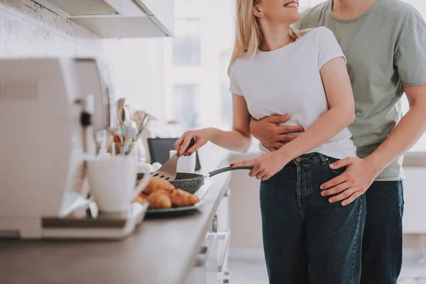 Man och kvinna står vid spisen och laga mat — Stockfoto