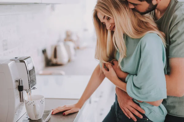 Man står på kök och kramar sin fru med ömhet — Stockfoto