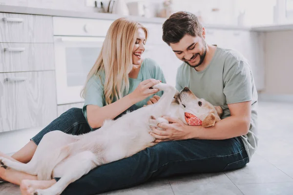 Familia feliz con perro recuperador de oro contento — Foto de Stock