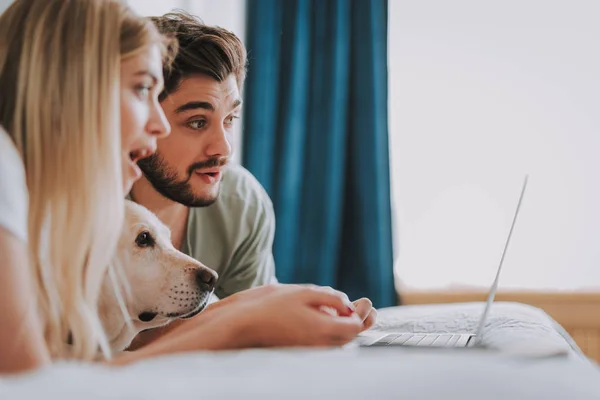 Agradable joven pareja aplicando el Internet en casa — Foto de Stock