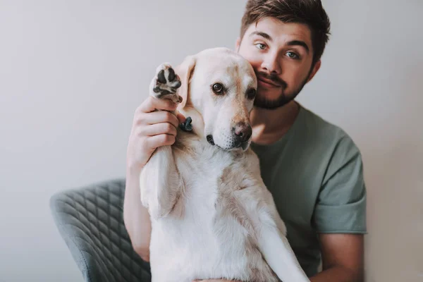 Homem barbudo agradável sentado com seu cão — Fotografia de Stock