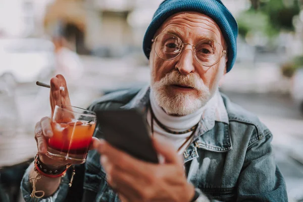 Vieil homme élégant dans un café avec smartphone à la main — Photo