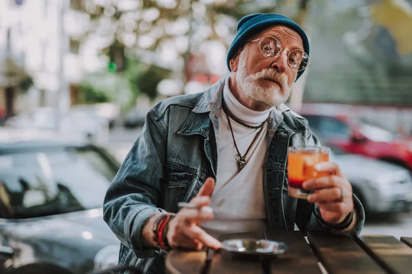Élégant vieil homme tient cocktail en plein air — Photo