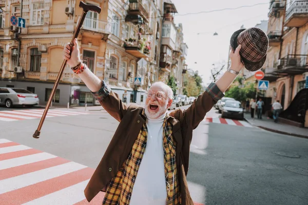 Стильный веселый старик, наслаждающийся жизнью — стоковое фото