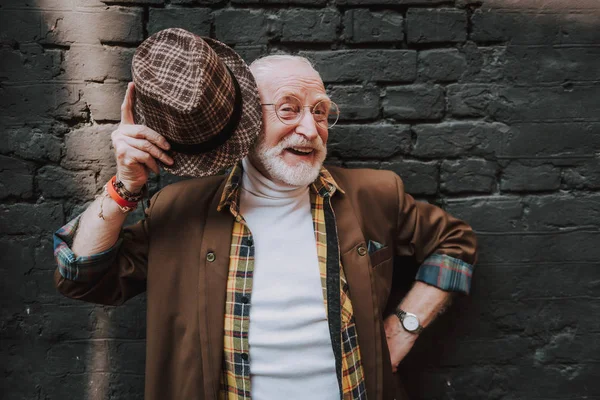 Retrato del viejo alegre asomándose a su sombrero — Foto de Stock