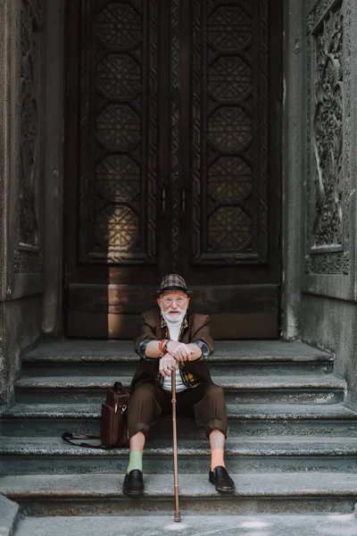 Feliz homem sênior está descansando em passos — Fotografia de Stock