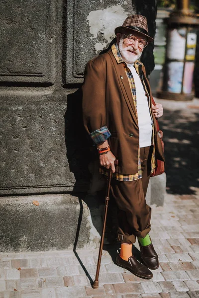 Alegre anciano elegante apoyado contra la pared — Foto de Stock