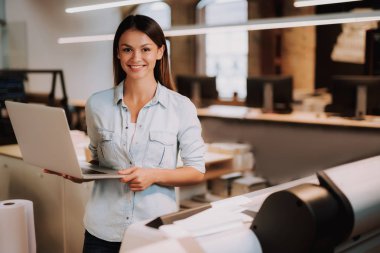 Laptop ayakta Office ile çekici genç bayan
