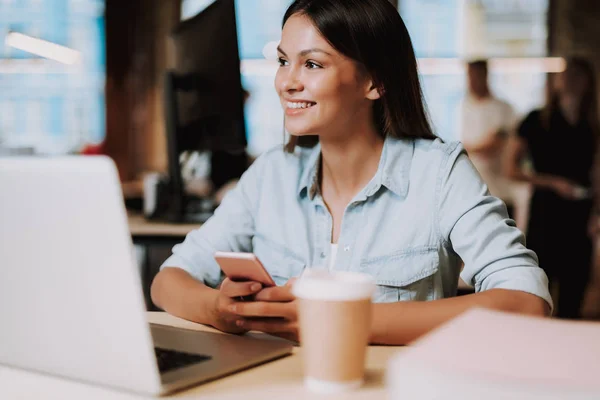 Vrolijke jongedame, houden van mobiele telefoon op werk — Stockfoto