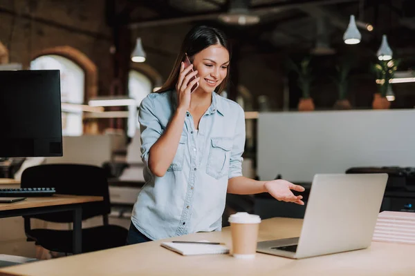 Sorridente giovane signora che parla sul cellulare in ufficio moderno — Foto Stock