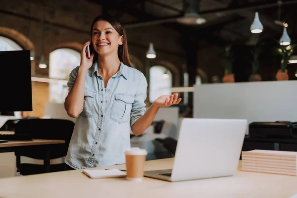 Glad ung dam talar på mobiltelefon på moderna kontor — Stockfoto
