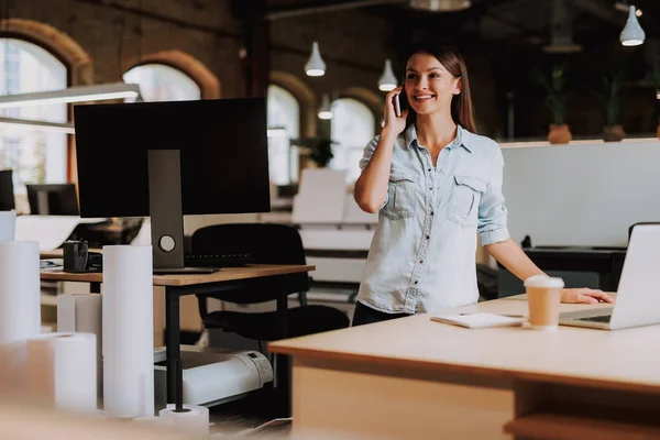 Aantrekkelijke jonge dame praten op mobiel op moderne kantoor — Stockfoto