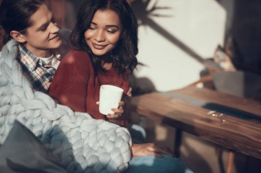 Romantik Çift onlara sıcak battaniye ile cuddling ederken gülümseyen