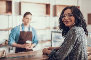 Gülümseyen ve kafede olurken bakıyorsun neşeli bayan
