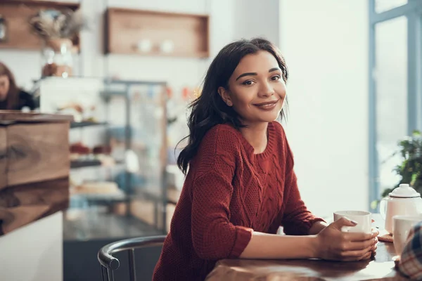 Señora tranquila sentada en la mesa de la encantadora cafetería y sonriendo — Foto de Stock