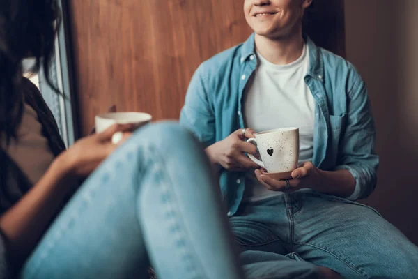 Hombre alegre sonriendo y sosteniendo la taza de té en sus manos —  Fotos de Stock