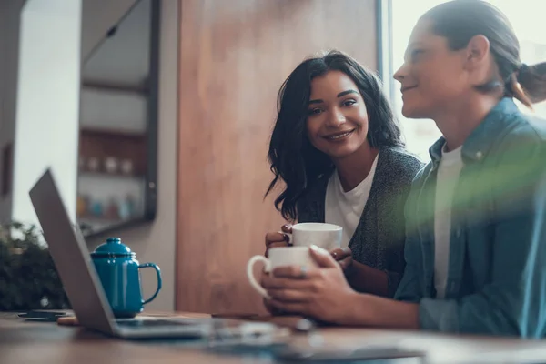 Молода пара посміхається і насолоджується чаєм в кафе — стокове фото