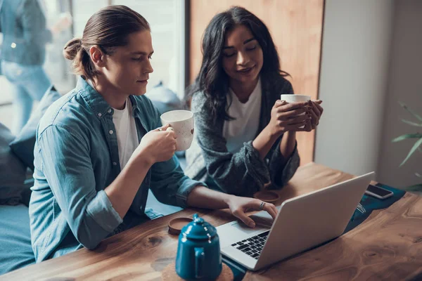 Ung man och kvinnor tittar på skärmen på laptop medan du sitter tillsammans — Stockfoto