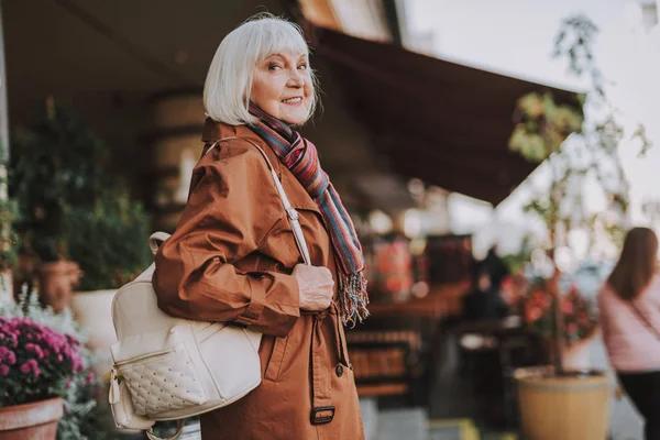 Stylish senior lady with backpack posing on the street — Stock Photo, Image