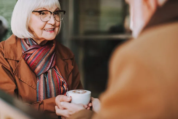 Vieja con bebida caliente pasar tiempo con el marido en la cafetería al aire libre — Foto de Stock