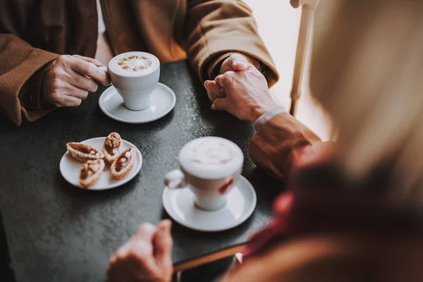 Äldre par njuter av cappuccino och dela anbud ögonblick på café — Stockfoto