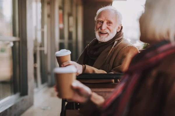 Радостный старик проводит время с женой в кафе на открытом воздухе — стоковое фото