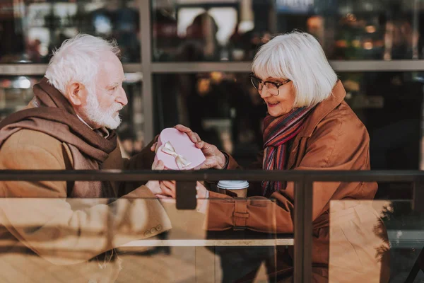 Hombre barbudo mayor dando un bonito regalo a su esposa — Foto de Stock