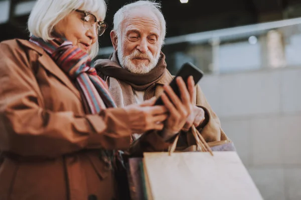 Belo casal de idosos olhando para o celular na rua — Fotografia de Stock