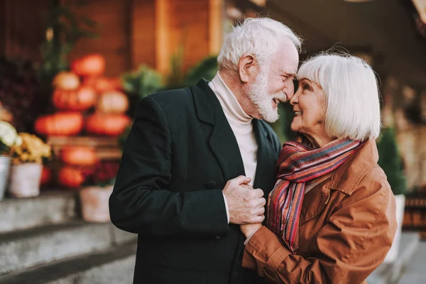 Glædelig senior par rører næser på gaden Royaltyfrie stock-fotos