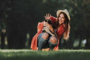 Mutlu kadın köpeğini ellerinde tutuyor