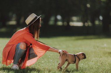 Kadın köpeğini güneşli Park ile yürüyor