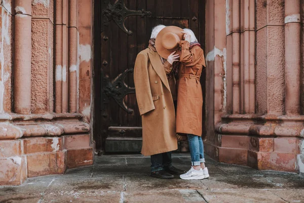 Stilvolles Senioren-Paar bedeckt Gesichter mit Hut — Stockfoto