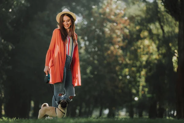 Юная леди стоит в парке со своей собакой — стоковое фото